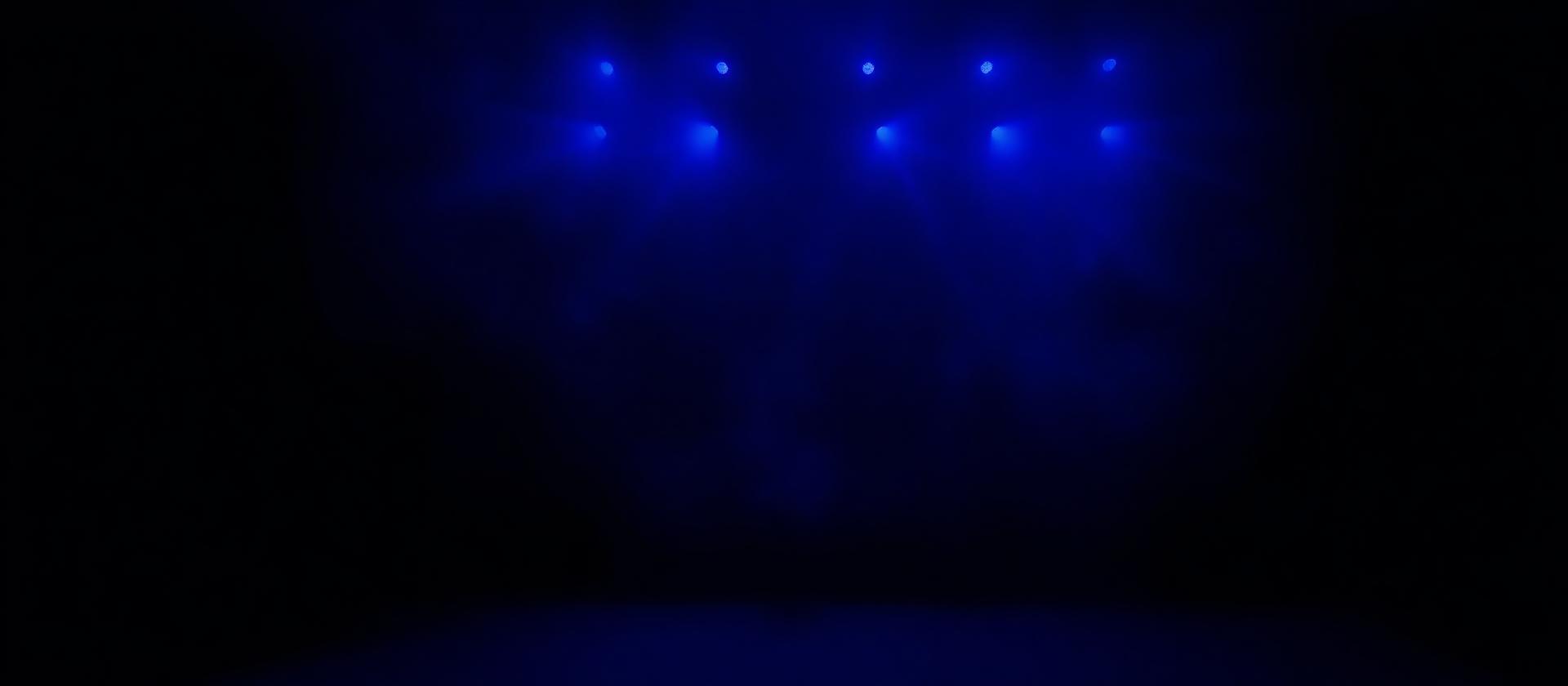 Kova Lane singing into a condenser microphone in a small studio lit by a single lamp